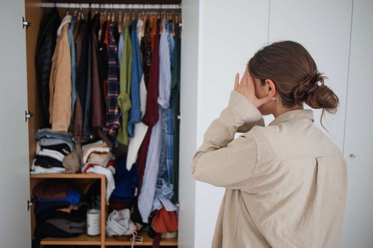donna di spalle che guarda l'armadio