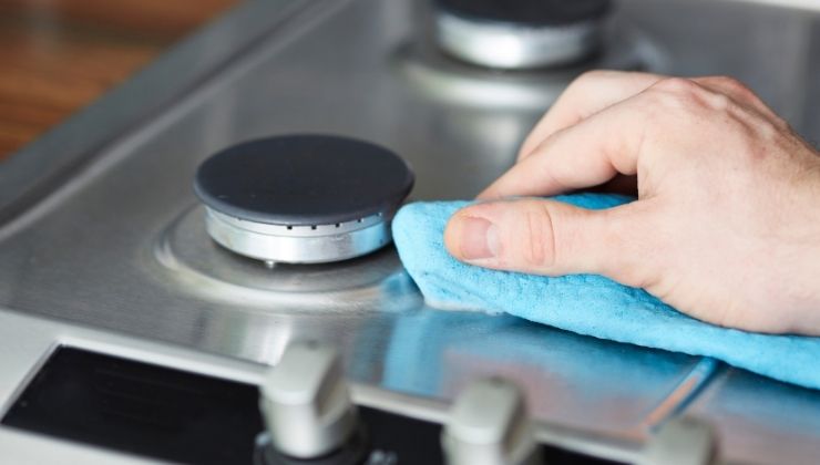 donna pulisce piano cottura 